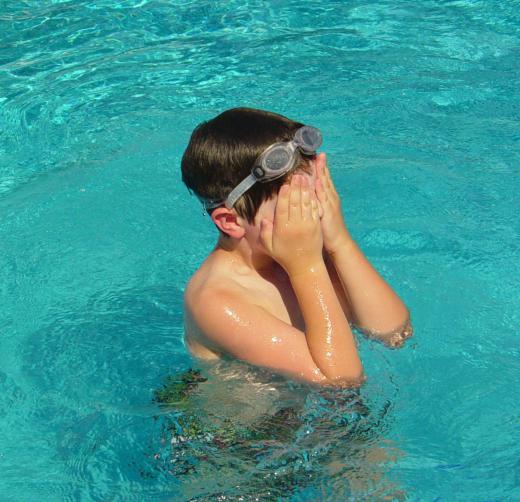 A person uses sound to detect other players in a swimming pool during the game of Marco Polo.