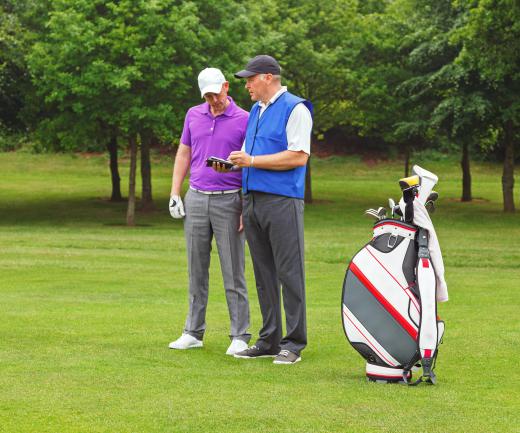 Caddies offer advice to golfers on shot distance and club selection.