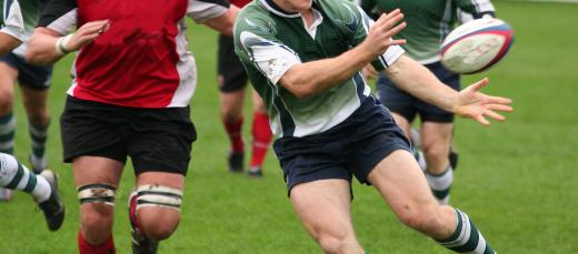 In rugby, players must advance the ball past the opposing team's goal line by passing to each other.