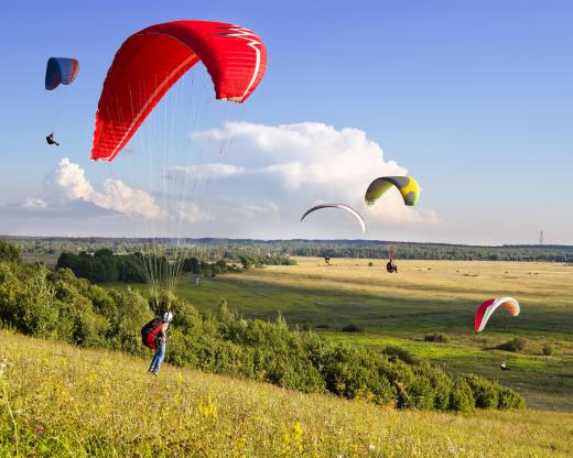 Paragliders soar in the sky.