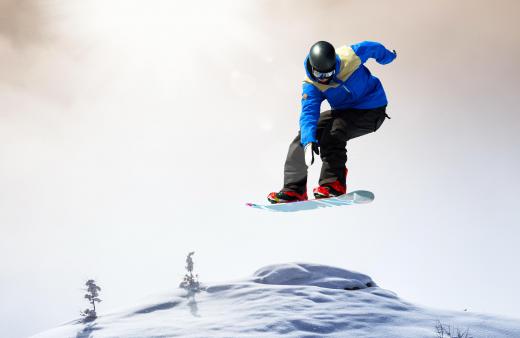 A snowboarder must balance on a single board without poles.