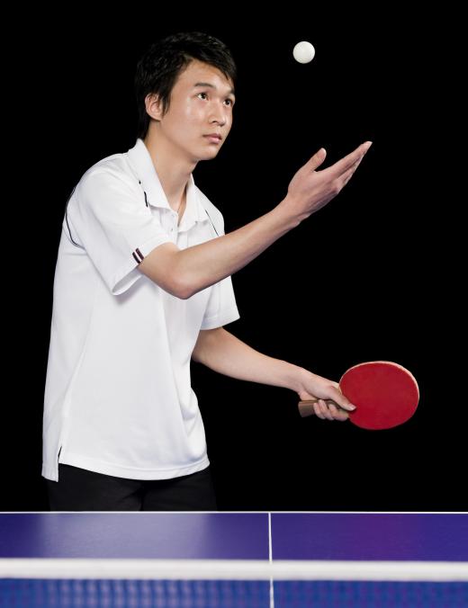 Ping pong player serving the ball.