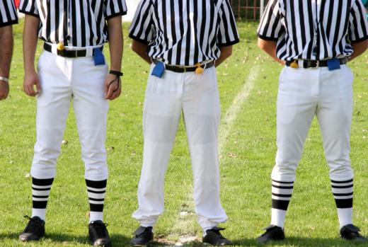 Multiple officials oversee a football game.