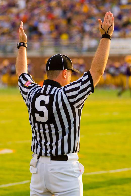 A referee holds up both arms to signal that a touchdown, worth six points, has been scored.