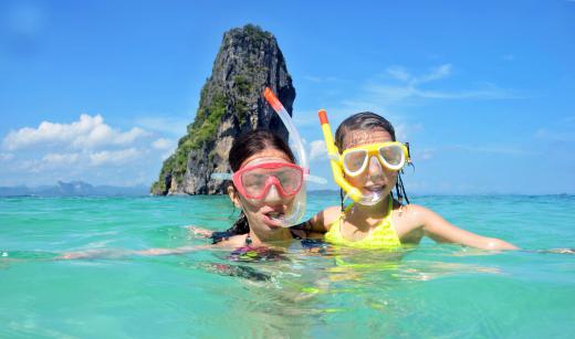 Two girls having fun while snorkeling on vacation.